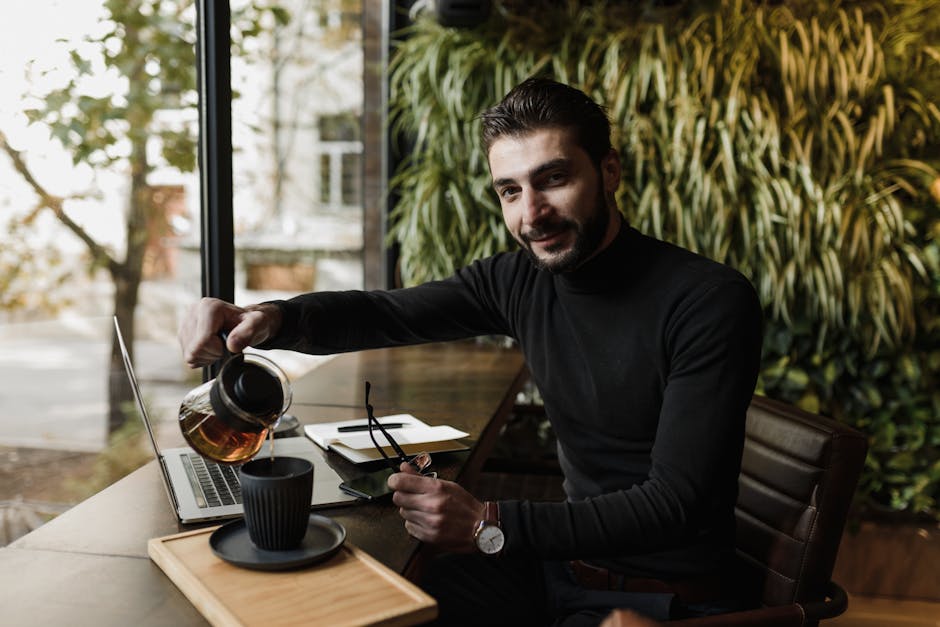 Person smiling and sitting comfortably with a cup of tea near a window